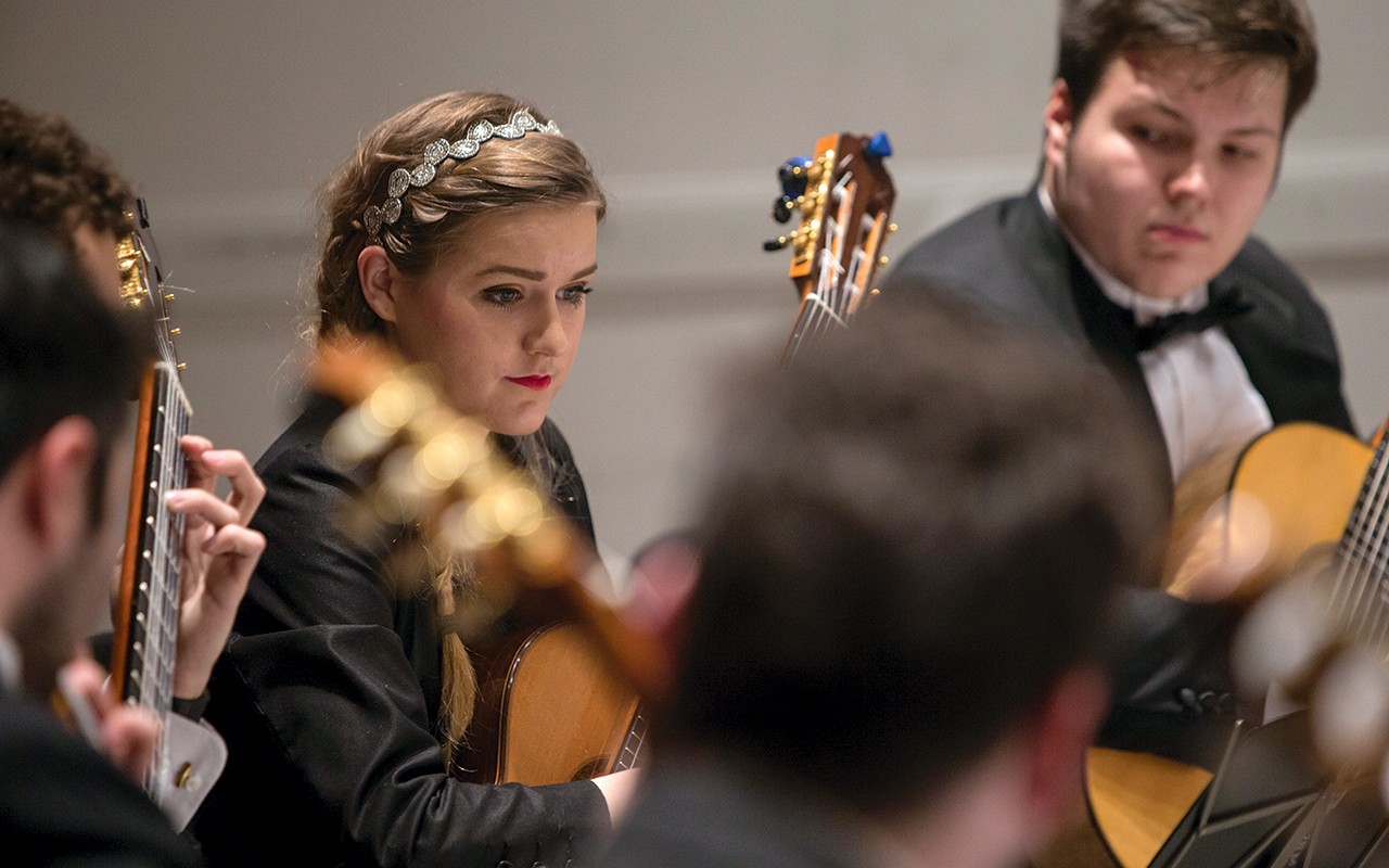 A female student performs on the classical guitar during Moveable Feast 