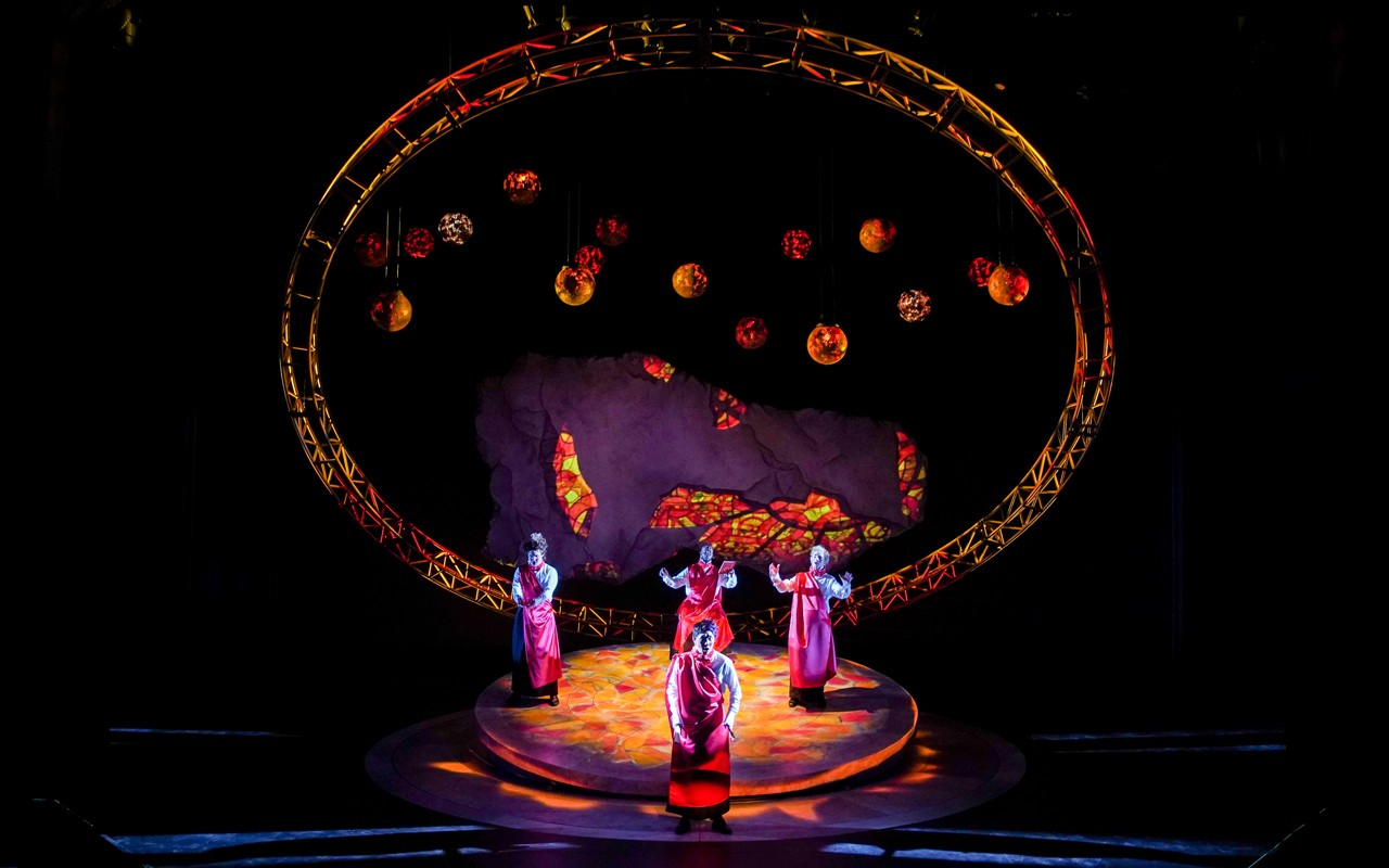Four students stand surrounded by a stylized representation of the solar system in a performance image from CCM's Spring 2022 production of the opera "Galileo Galilei." Photo/Mark Lyons