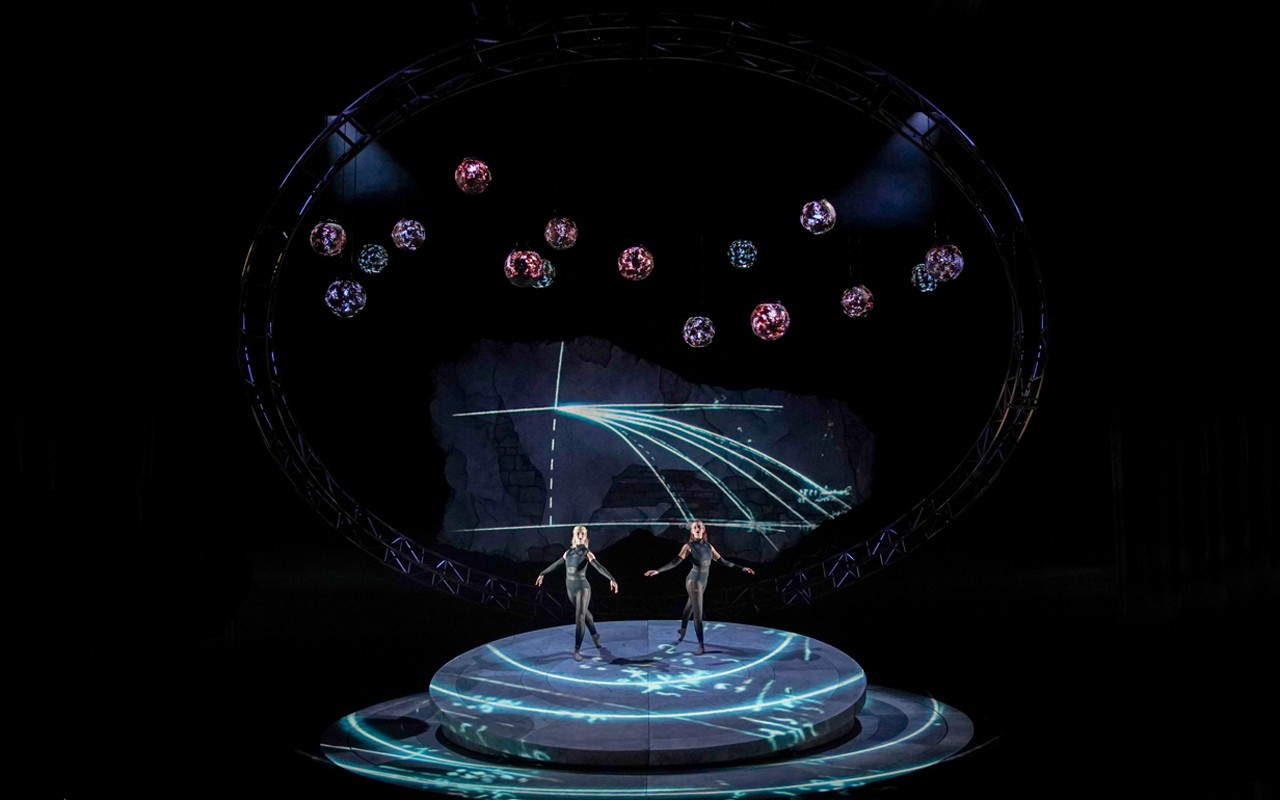 Two students stand surrounded by a stylized representation of the solar system in a performance image from CCM's Spring 2022 production of the opera "Galileo Galilei." Photo/Mark Lyons