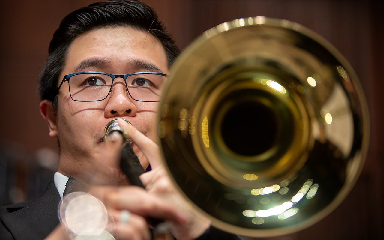 Male trombone student performs with the concert orchestra in Corbett Auditorium