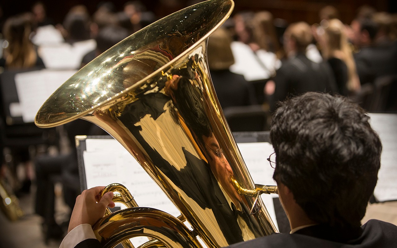 Male tuba student performs with the wind ensemble in Corbett Auditorium