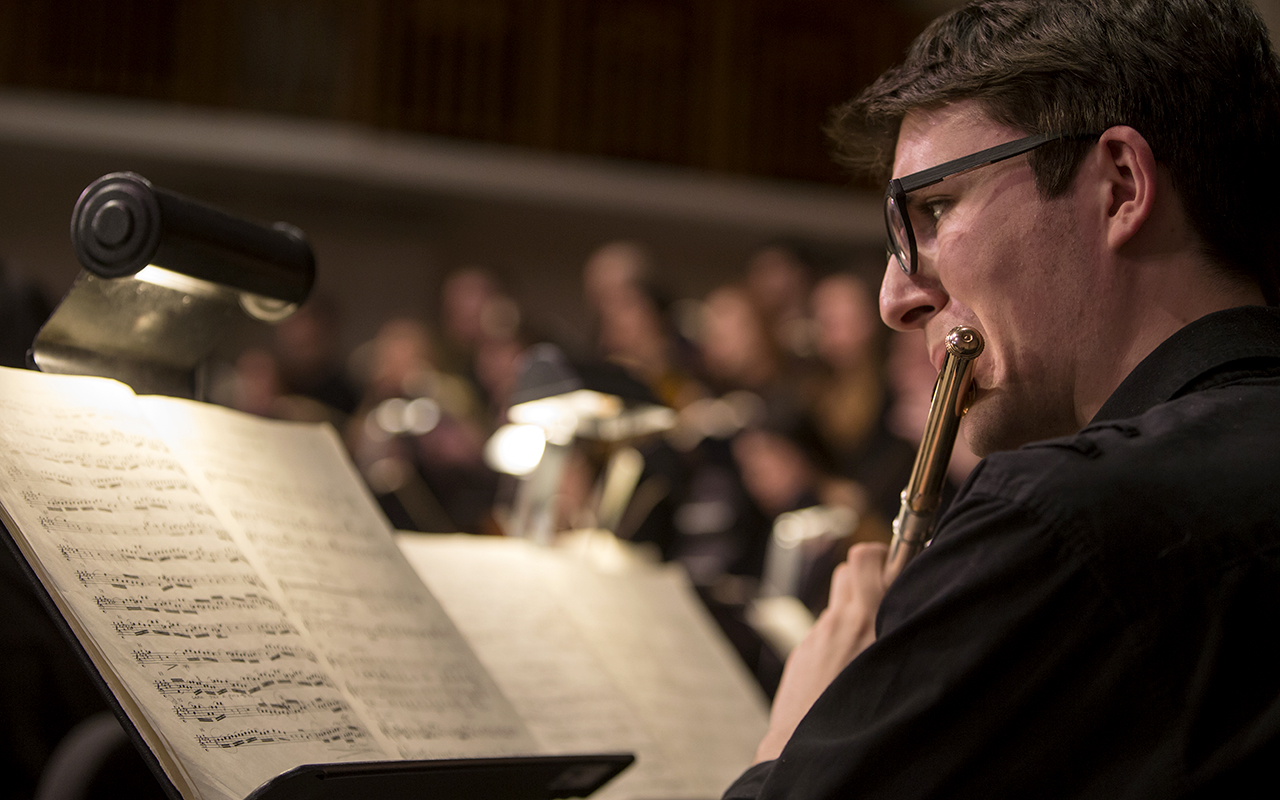 A male student performs on the flute during a perfromance of Bach's St. Matthew Passion